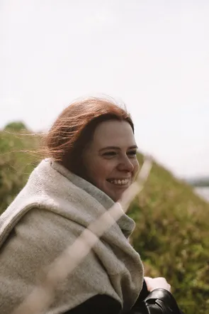 Smiling woman wrapped in a wool scarf outdoors