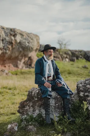 Gaucho seated on a rock in the countryside